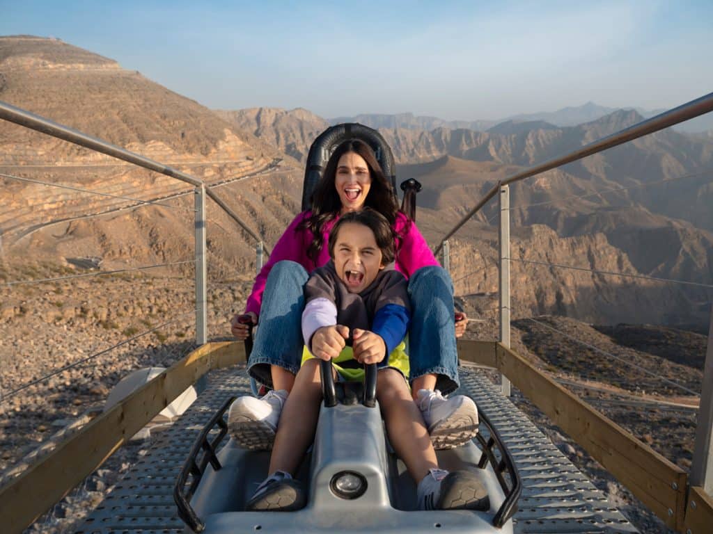 Family day out in Dubai at a beach park with children playing